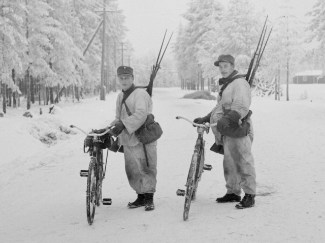Bicycle troops—likely Swedish volunteers—carrying captured weapons. The Finns would patrol roads after Russian columns had passed through and collect anything of use. They captured vast amounts of materiel during the war— everything from rifles and radio sets to abandoned tanks. Photo credit SA-Kuva