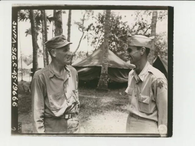 Major General Charles E. Hurdis (L), commanding officer, 6th Infantry Division, congratulating 2nd Lt. Donald E. Rudolph on his promotion, June 27, 1945.