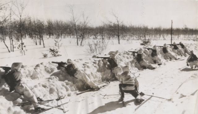 Soldiers on skis practice their marksmenship under simulated gas attacks during the 1939-40 winter exercises at Pine Camp, NY.  Courtesy Doug Schmidt/National Association of the 10th Mountain Division, Inc.