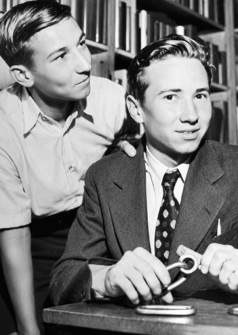 Glen Dawson (1912–2016, shown here holding a piton with his brother looking on) was one of the defining figures of the Golden Age of Sierra climbing. A member of the Southern California Chapter of the Sierra Club and a founder of its Rock Climbing Section, he was the first to bring modern roped climbing techniques and equipment to Zion National Park. His climbing résumé included numerous first ascents in the High Sierra, repeats of classic alpine routes in the Alps and Dolomites, climbs of Higher Cathedral Spire in Yosemite, the first ascent of the East Buttress of Mount Whitney, and the first ascent of the Mechanic's Route on Tahquitz Rock, which became the benchmark for 5.8 climbing in the years before World War II. During World War II, Dawson served as a rock climbing and skiing instructor with the 10th Mountain Division at Camp Hale and later in Italy, earning a Bronze Star for combat service. After the war, he succeeded his father as proprietor of Dawson's Book Shop in Los Angeles, becoming one of America's foremost antiquarian booksellers and publishers while remaining an active historian and steward of climbing's early legacy. At the time of his death in 2016, at age 103, he was the Sierra Club's longest-tenured member, with more than 94 years of membership.